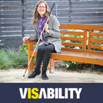 Image of a woman holding a white cane with the VisAbility logo below